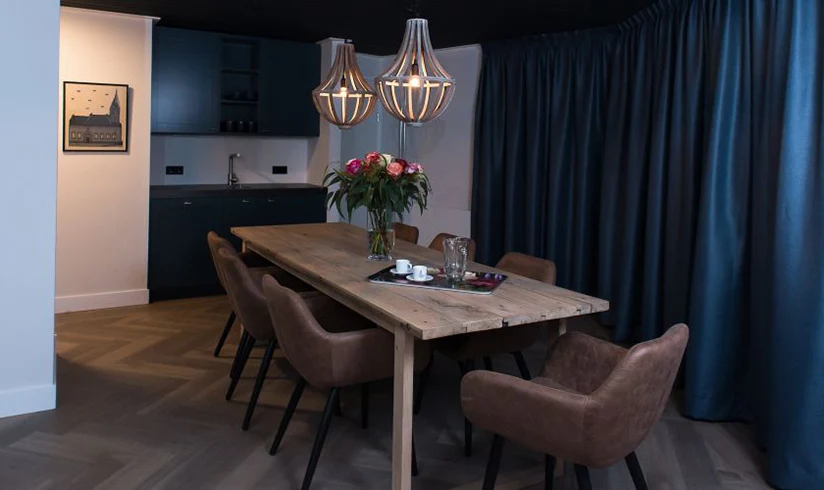 Kamer met een grote eettafel en bruine stoelen